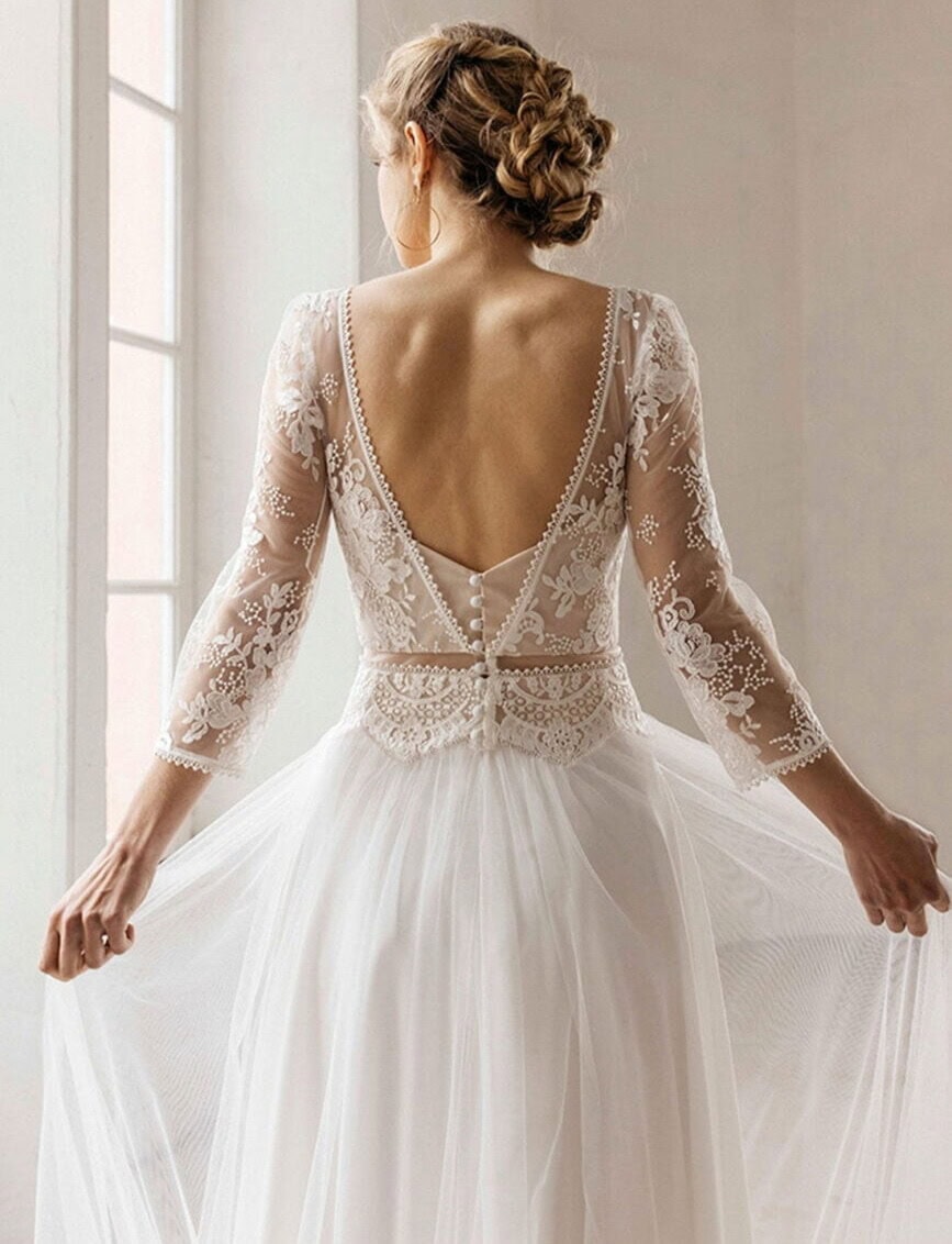 Phoenix dos Lambert Créations robe de mariée fluide top dentelle décolleté V manches longues dentelle ceinture fine jupe en tulle magasin de robes de mariée Annecy Paris