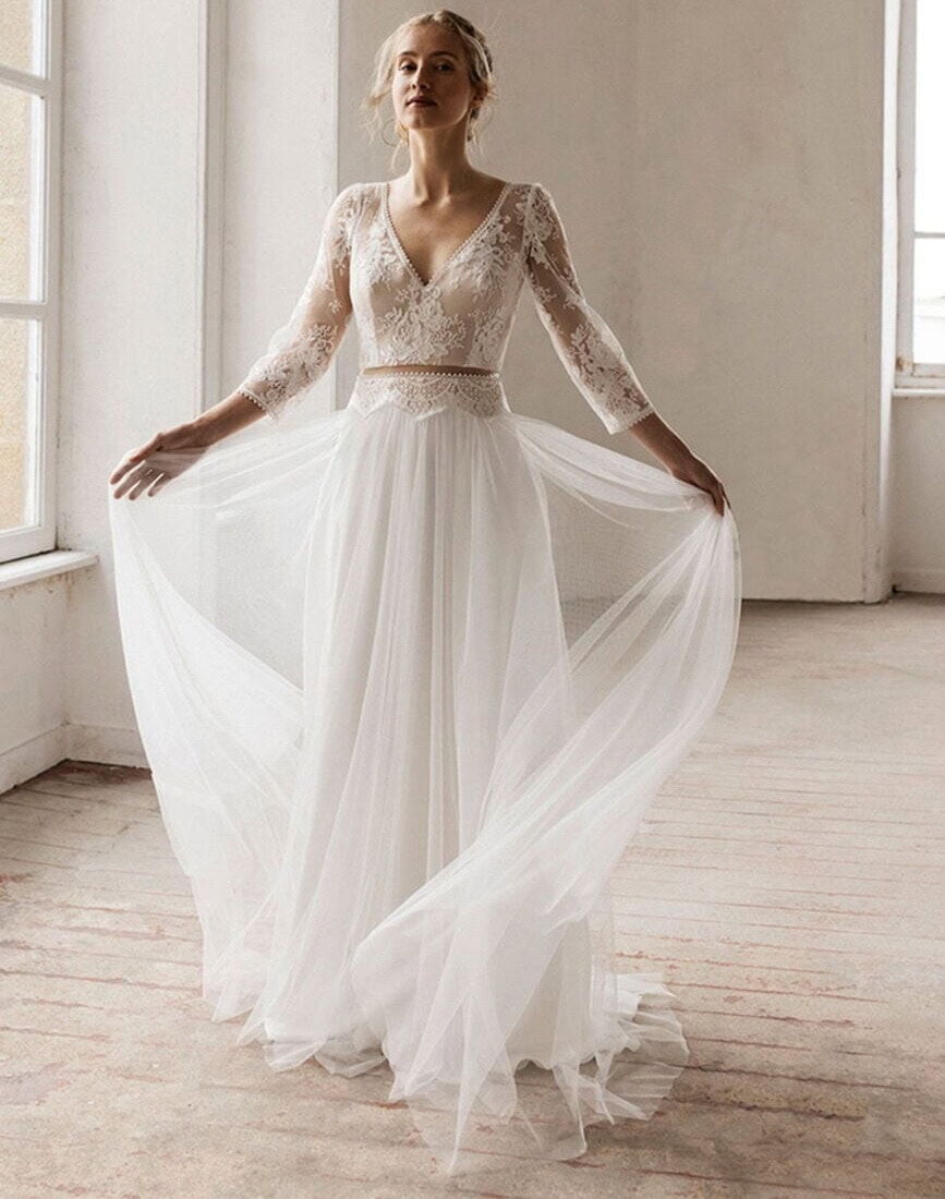 Phoenix face Lambert Créations robe de mariée fluide top dentelle décolleté V manches longues dentelle ceinture fine jupe en tulle magasin de robes de mariée Annecy Paris