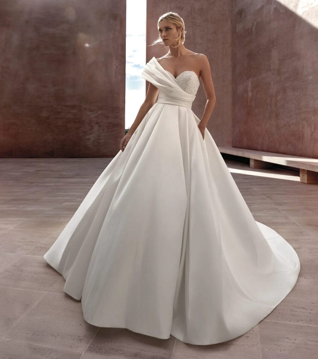 Luise face Justin Alexander robe de mariée princesse bustier perlé coeur manches asymétrique satin drapé jupe à plis satin traîne magasin de robes de mariée Paris