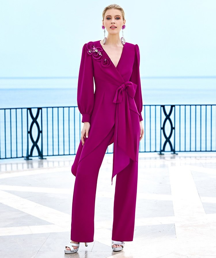 Vêtement féminin en fuchsia avec détails floraux et ceinture nouée, parfait pour une occasion spéciale ou une sortie en bord de mer. Conçu pour un style chic et moderne.