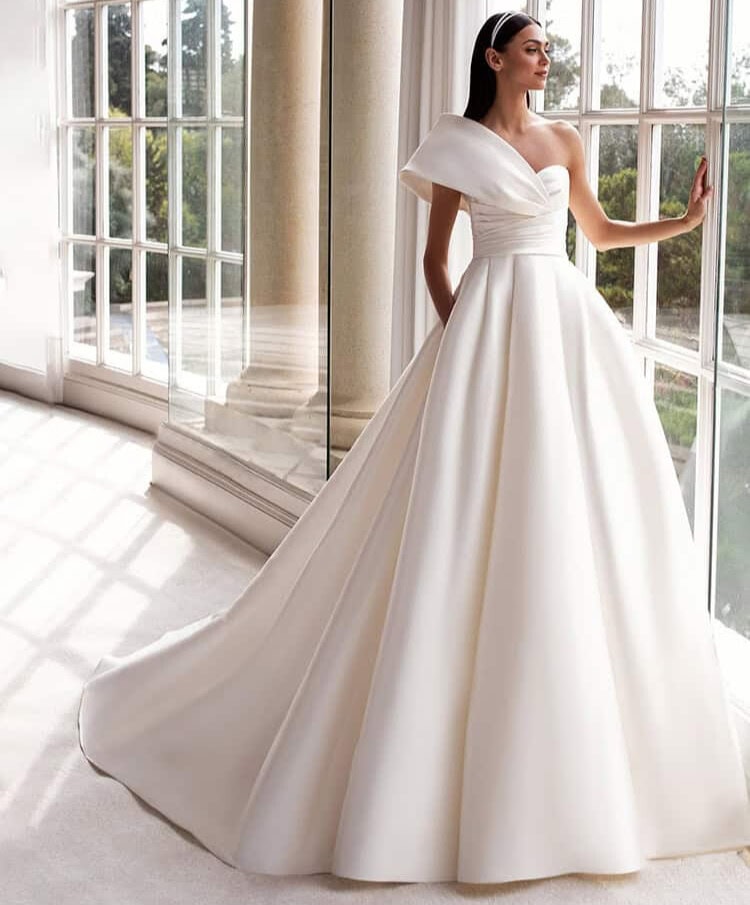 Sedna face Pronovias robe de mariée princesse mikado bustier coeur manche oversize asymétrique jupe plis traîne magasin de robes de mariée Paris Annecy