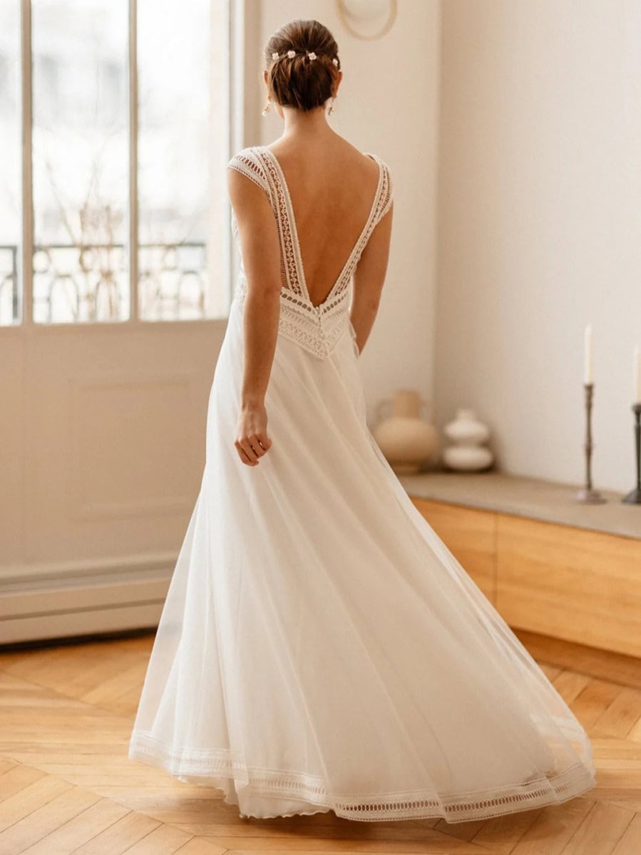 Vêtement de mariée blanc en dentelle avec dos nu, élégance et finesse pour une robe de mariage romantique et sophistiquée. Parfait pour une occasion spéciale ou un mariage de rêve.