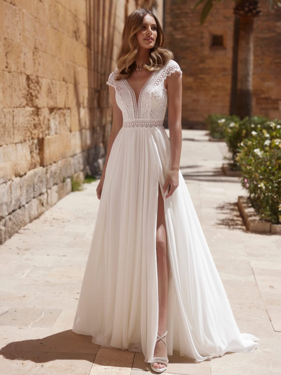 Balade romantique en robe de mariée blanche avec décolleté en V et détails en dentelle.