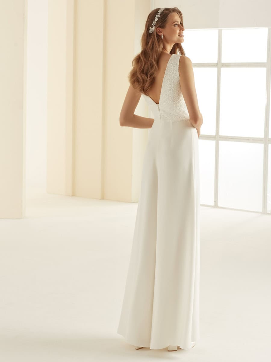 Léger et élégant, robe de mariée blanche avec dos en dentelle et jupe fluide, idéale pour une cérémonie nuptiale sophistiquée et romantique. Parfaite pour une mariée recherchant un style chic et intem.