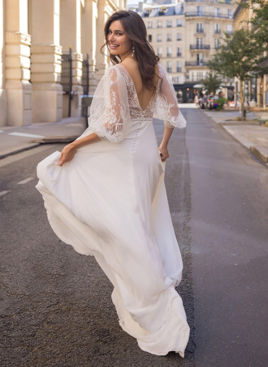 Aller à la plage, robe de mariée blanche élégante avec dentelle, style bohème chic, ambiance urbaine parisienne, mode nuptiale, look romantique, mariage en ville, tenue de cérémonie sophistiquée, élég.