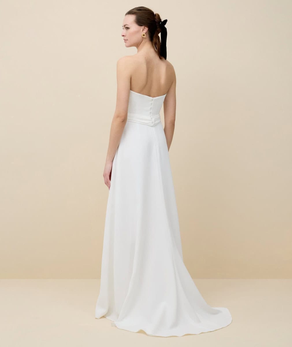 Robe de mariée blanche longue avec dos nu, parfaite pour un mariage élégant et sophistiqué, mettant en valeur la silhouette de la mariée.