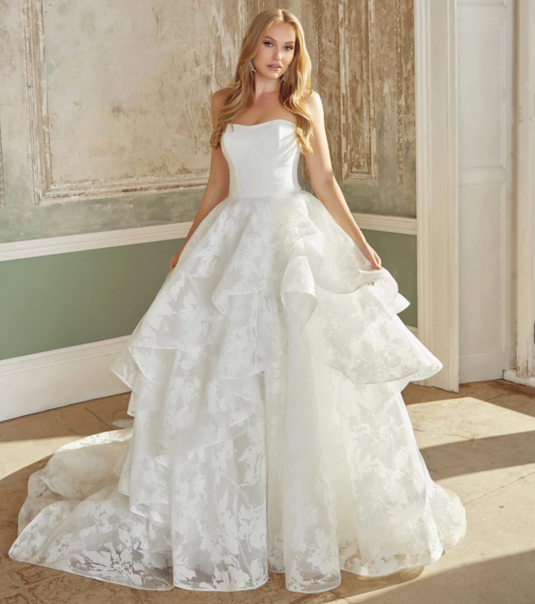 Une robe de mariée blanche avec jupe volumineuse et détails en dentelle.