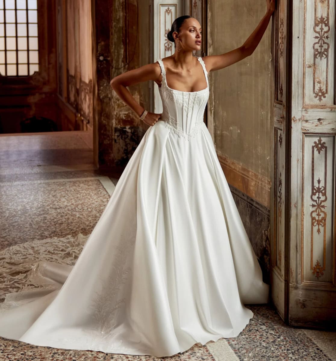 Robe de mariée en satin blanc avec dentelle, style classique et sophistiqué, parfaite pour un mariage élégant dans un lieu historique ou un château.