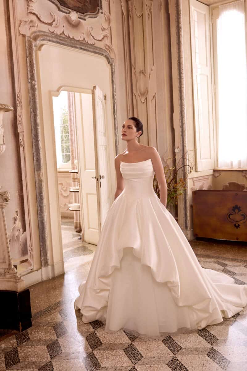Lottie face Justin Alexander robe de mariée princesse taffetas bustier droit drapé jupe asymétrique courte devant longue derriere sous jupe en tulle plat traîne boutique de robes de mariée Paris