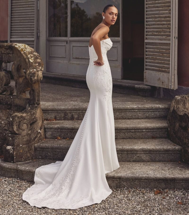 Robe de mariée blanche longue avec bustier en dentelle, style sophistiqué, parfait pour un mariage chic.