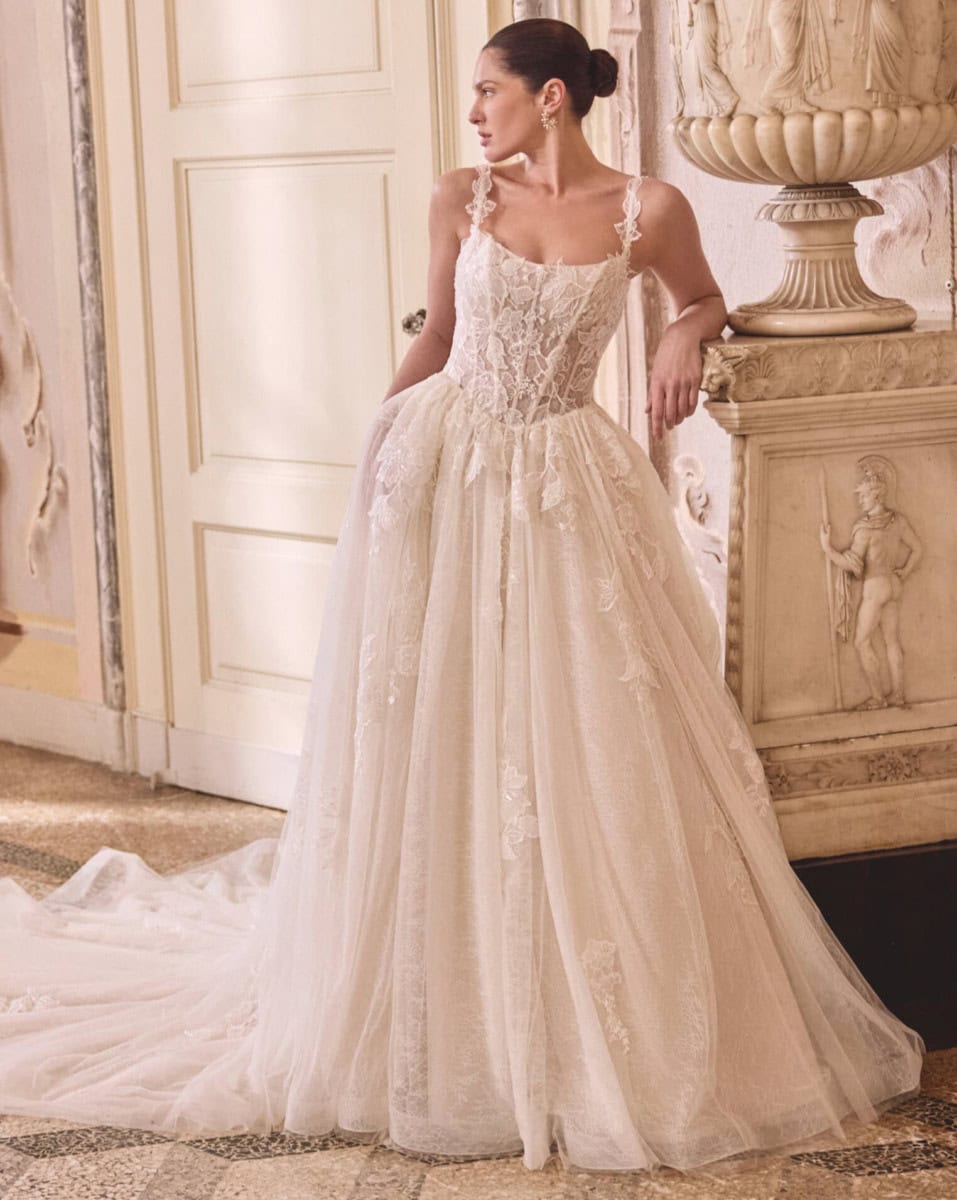 Vêtement de mariée en dentelle ivoire avec bustier ajusté et jupe fluide, parfait pour une occasion spéciale.