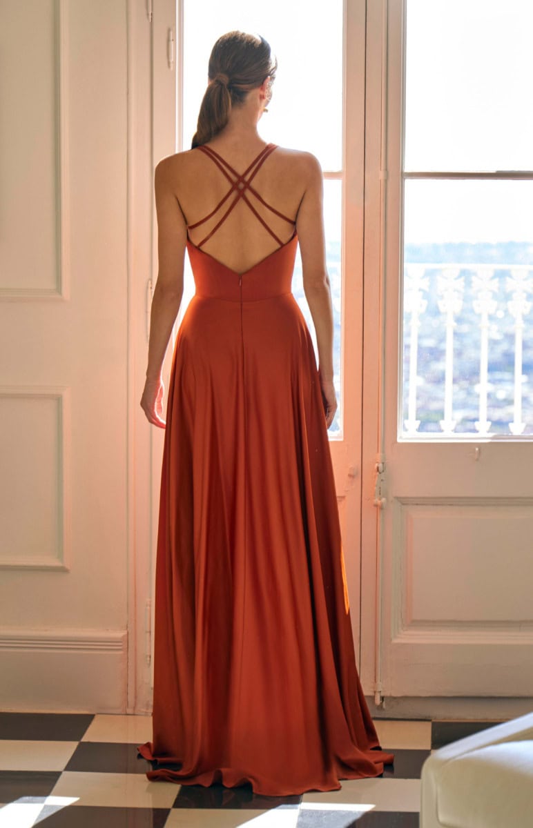 Robe longue rouge bivoacée avec dos nu et bretelles croisées, idéale pour une soirée ou un événement spécial. Conçue pour mettre en valeur la silhouette avec un tissu fluide et sophistiqué.