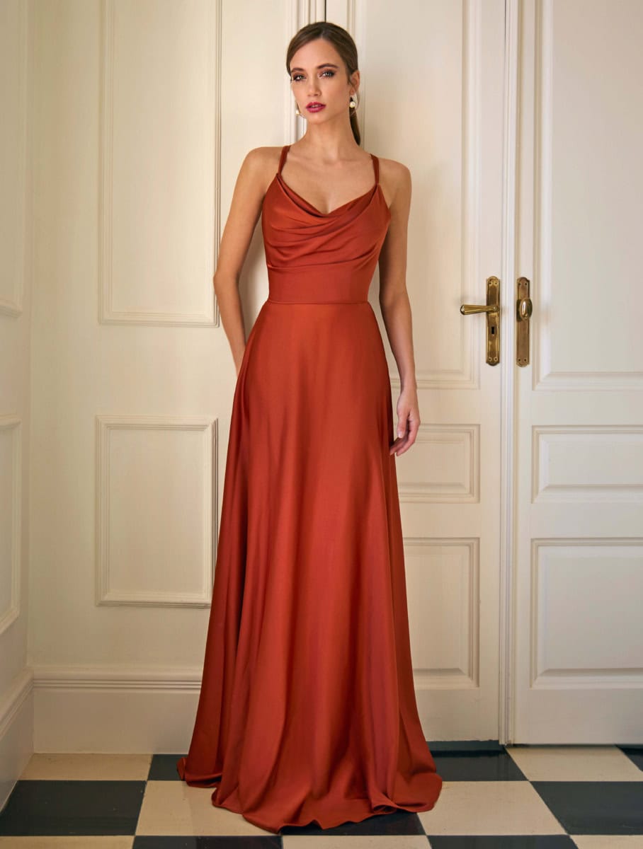 Robe longue en satin rouge brique avec décolleté en V et fines bretelles, idéale pour une soirée chic ou un événement spécial. Conçue pour mettre en valeur la silhouette avec élégance.