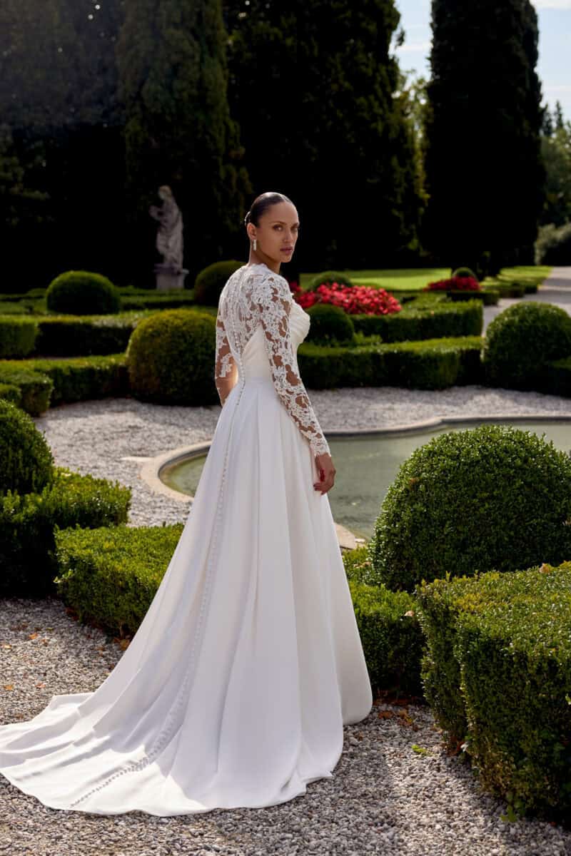 Katelyn dos Justin Alexander robe de mariée fluide A-line trapèze crêpe satin bustier vague drapé fente traîne manches longues dentelle boutique de robes de mariée Annecy