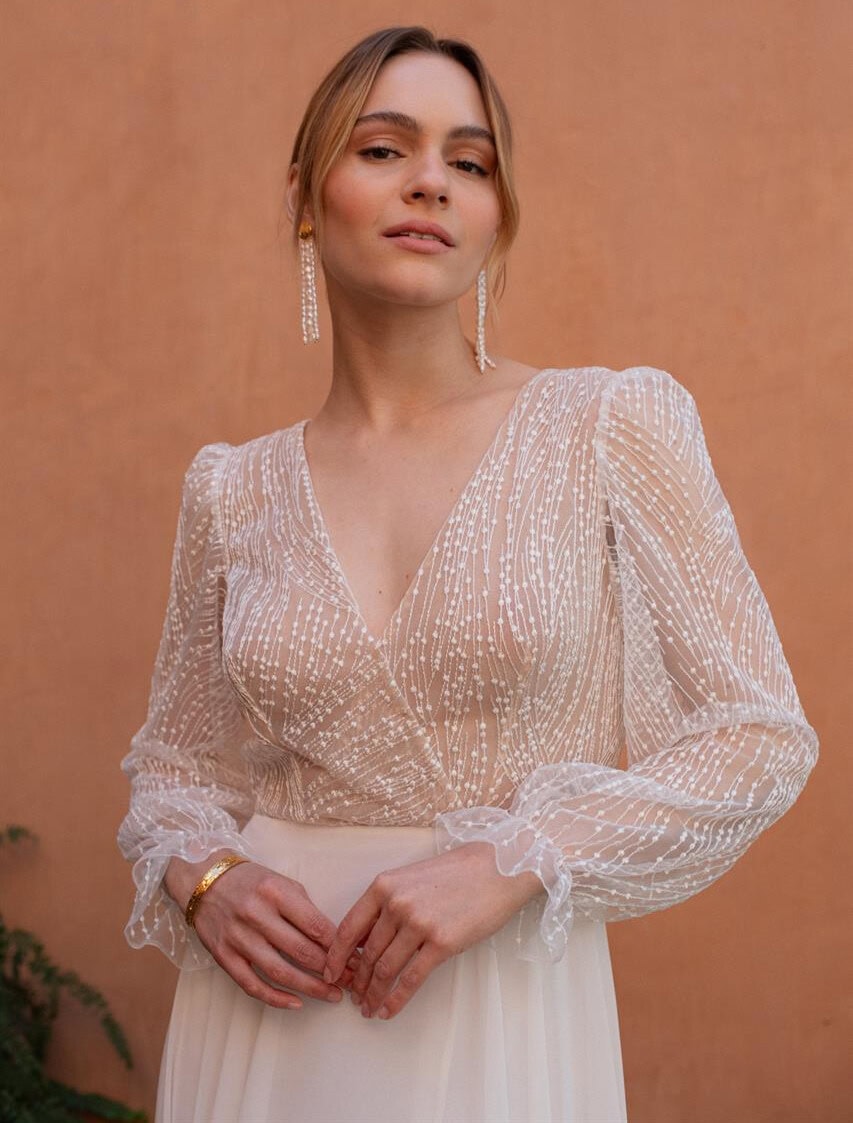 Petunia zoom face Rembo atelier robe de mariée fluide top dentelle décolleté cache coeur manches longues bouffantes dentelle jupe mousseline fluide magasin de robes de mariée Paris