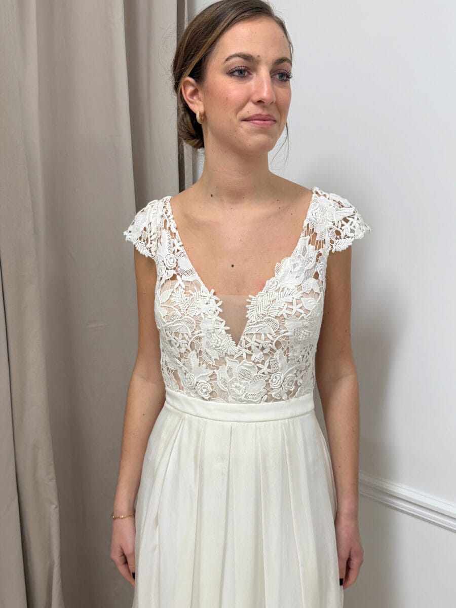 Pivoine zoom face robe de mariée fluide top guipure décolleté V manchettes ceinture taille dos papillon magasin de robes de mariée Paris Pivoine zoom face robe de mariée fluide top guipure décolleté V manchettes ceinture taille dos papillon magasin de robes de mariée Paris
