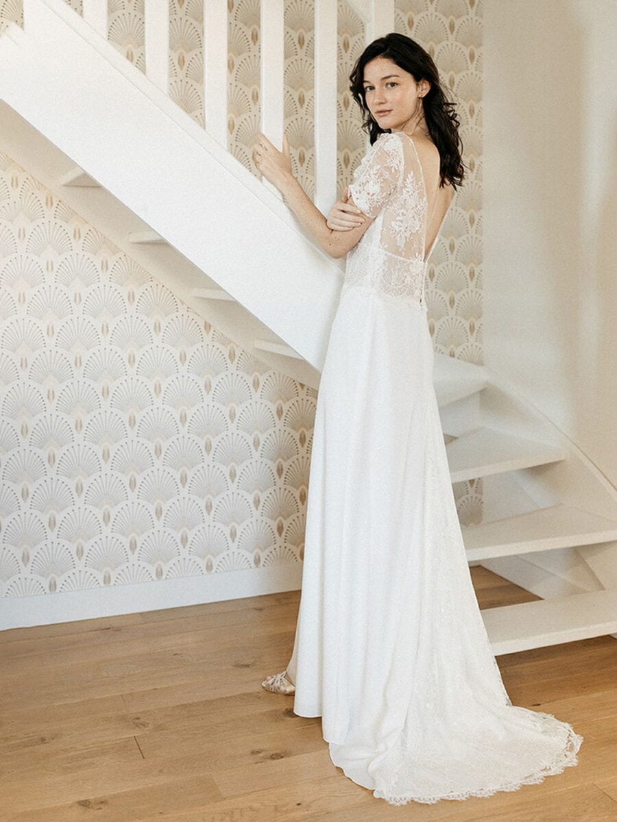 Celebes dos Lambert Créations robe de mariée fluide jupe droite top hanches en dentelle décolleté V manches tulipe dentelle traîne magasin de robes de mariée Annecy