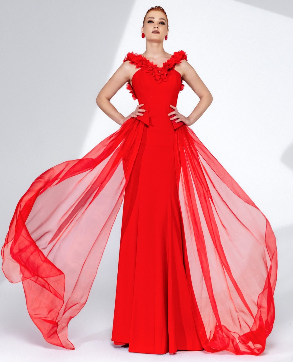 Balade en robe de soirée rouge avec détails floraux et tissu léger.