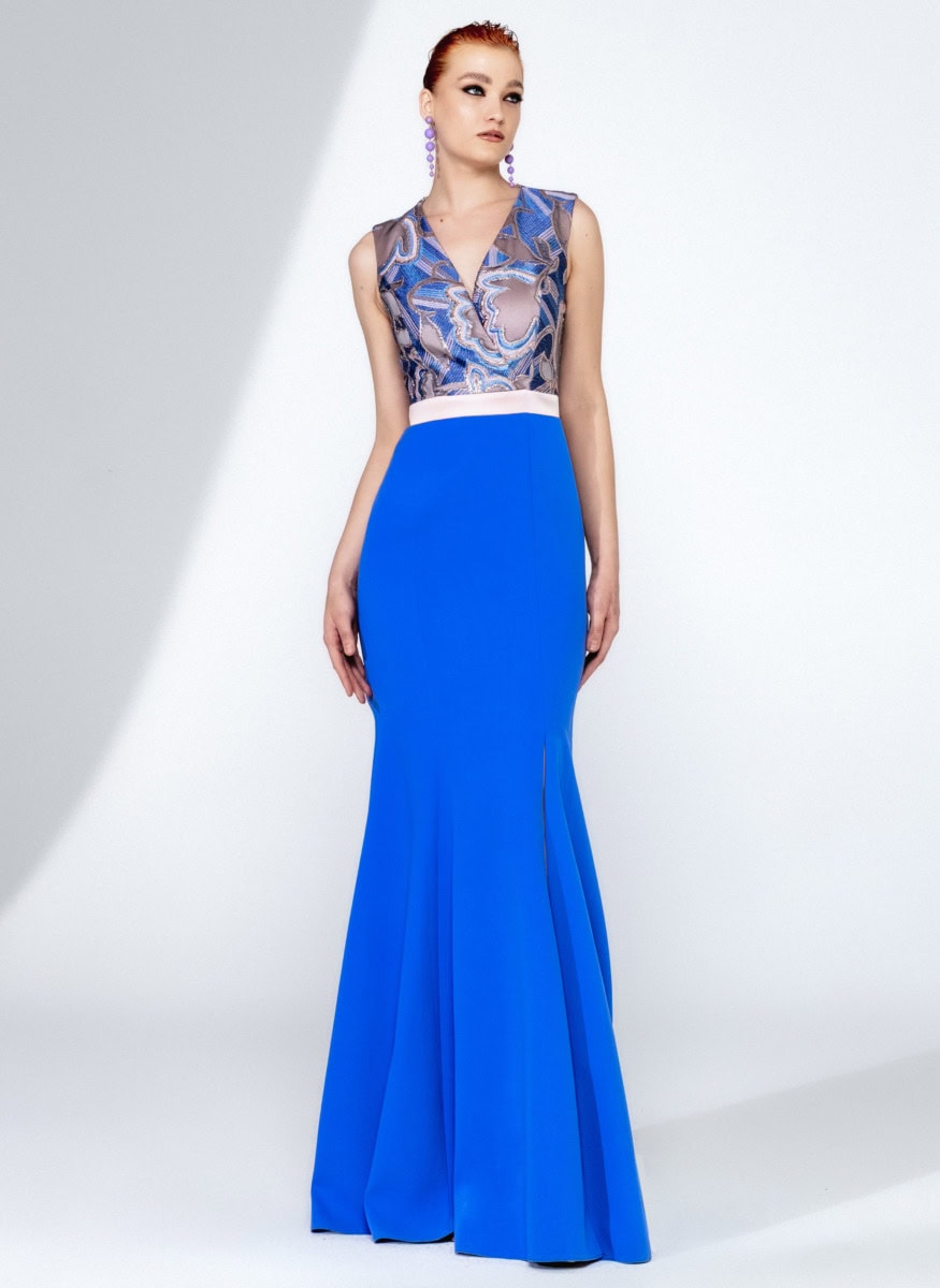 Robe de soirée longue bleue avec détails en dentelle et ceinture blanche, idéale pour événements formels ou galas. Conçue pour un look sophistiqué et moderne.
