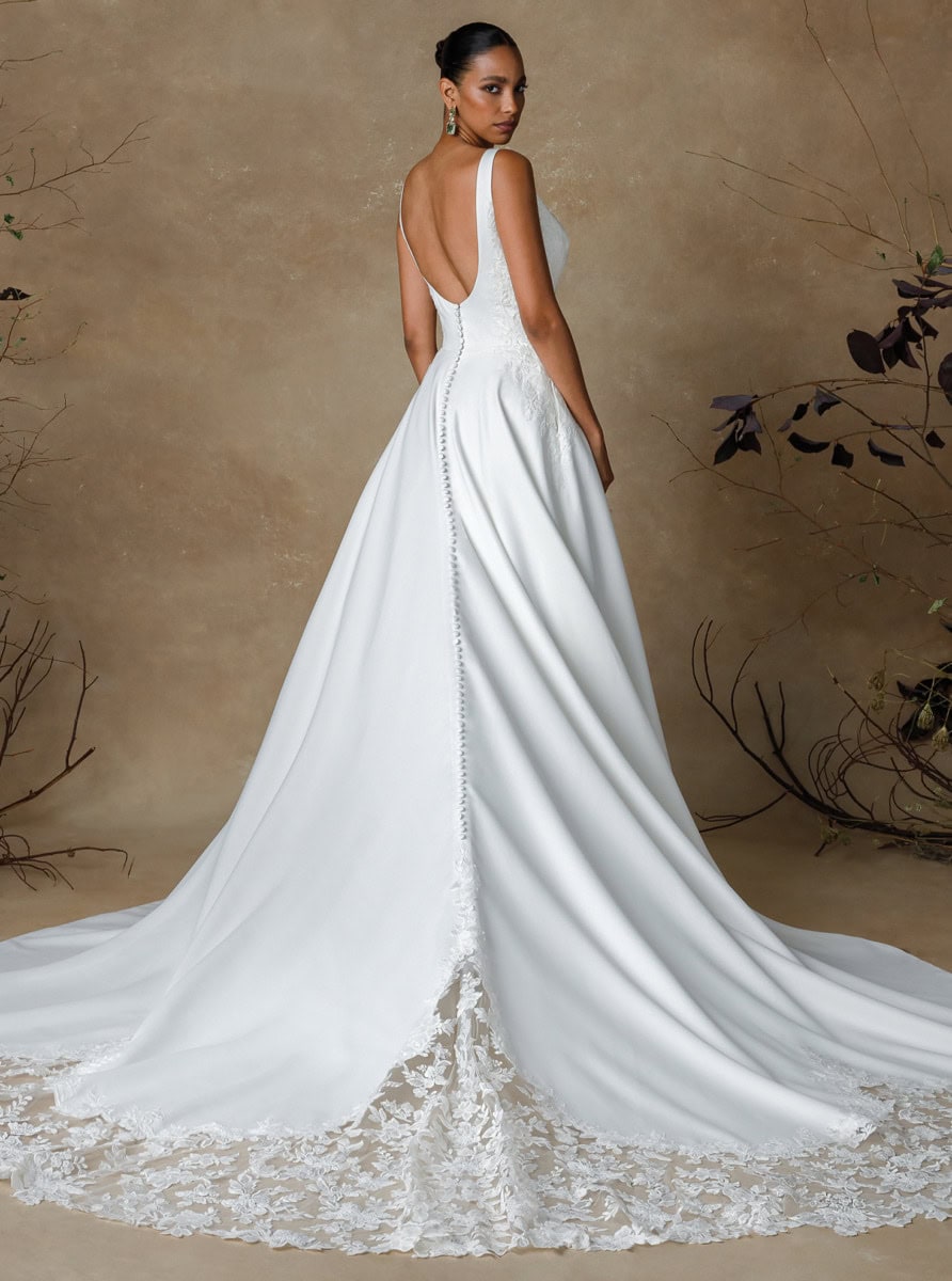 Robe de mariée Gibson élégante avec dos nu, détails en dentelle et traîne longue, parfaite pour une mariée sophistiquée.