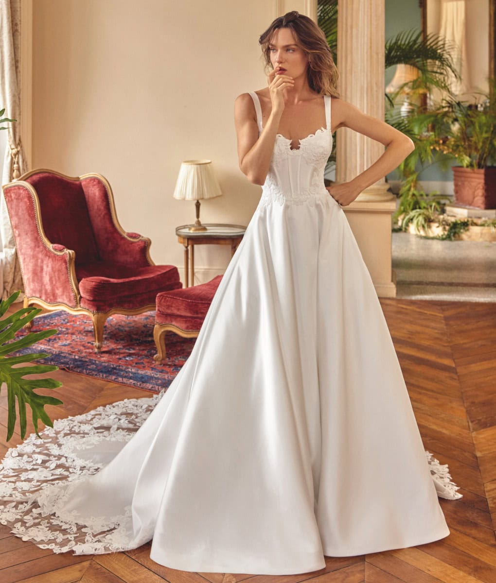 Robe de mariée blanche longue avec bustier en dentelle, parfaite pour un mariage romantique. Conçue pour mettre en valeur la silhouette, idéale pour une mariée sophistiquée.