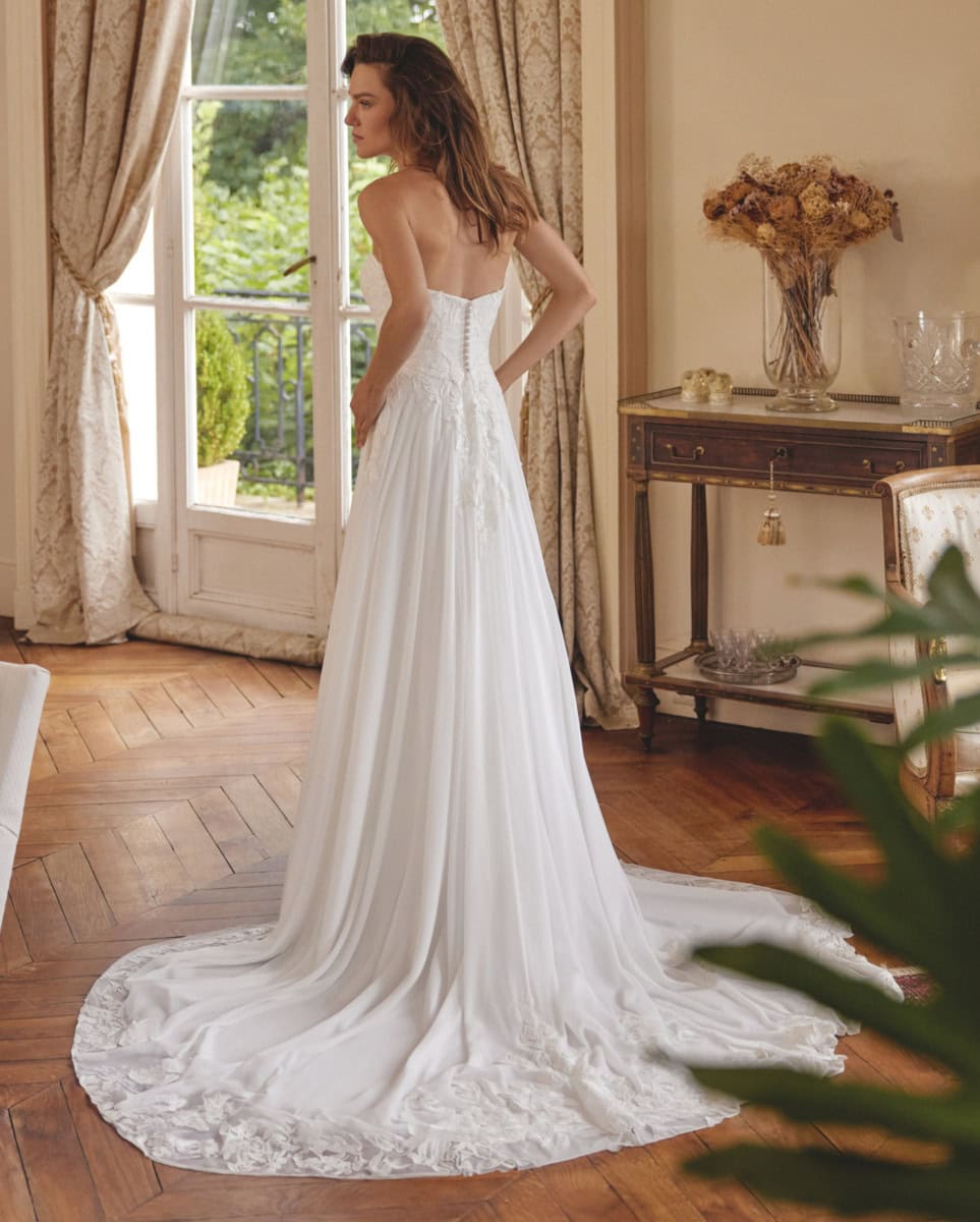 Robe de mariée longue en tissu léger avec corsage ajusté et jupe fluide, idéale pour un mariage romantique. Parfaite pour une mariée recherchant élégance et confort.