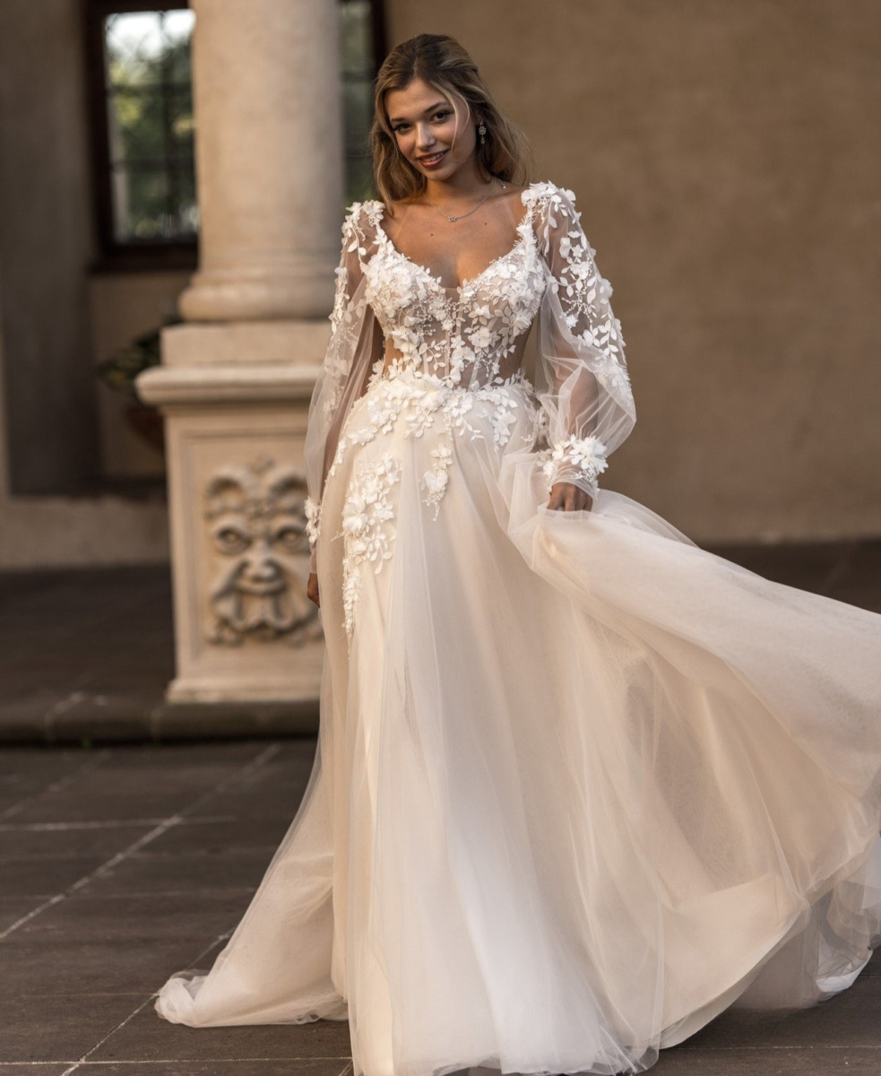 Allée de mariage élégante avec une robe de mariée en dentelle et tulle, portant une robe de créateur O'Scarlett, dans un décor intérieur sophistiqué avec colonnes et lumière naturelle.